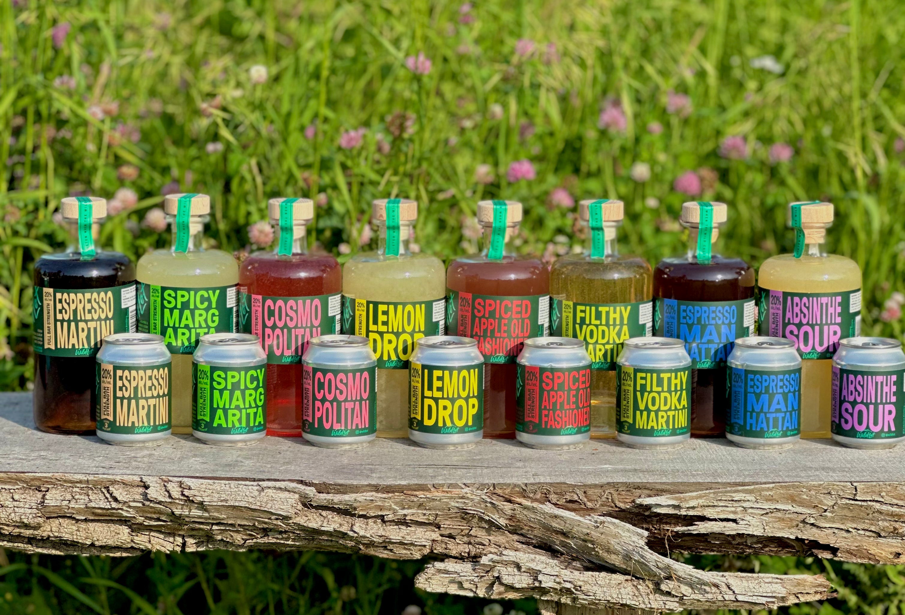 Assorted bottles of alcohol on a wooden surface with a natural background
